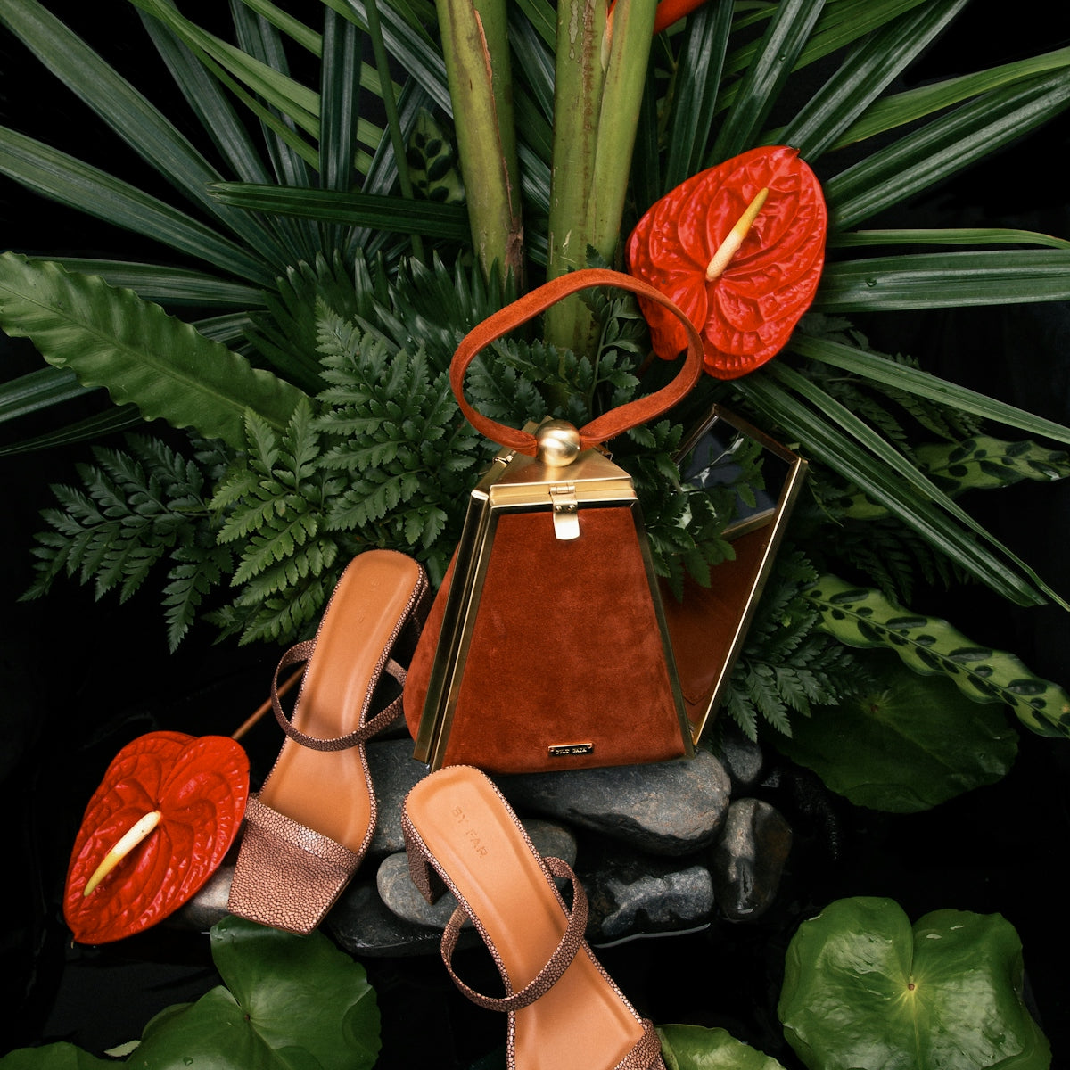 brown leather sling bag on green leaves