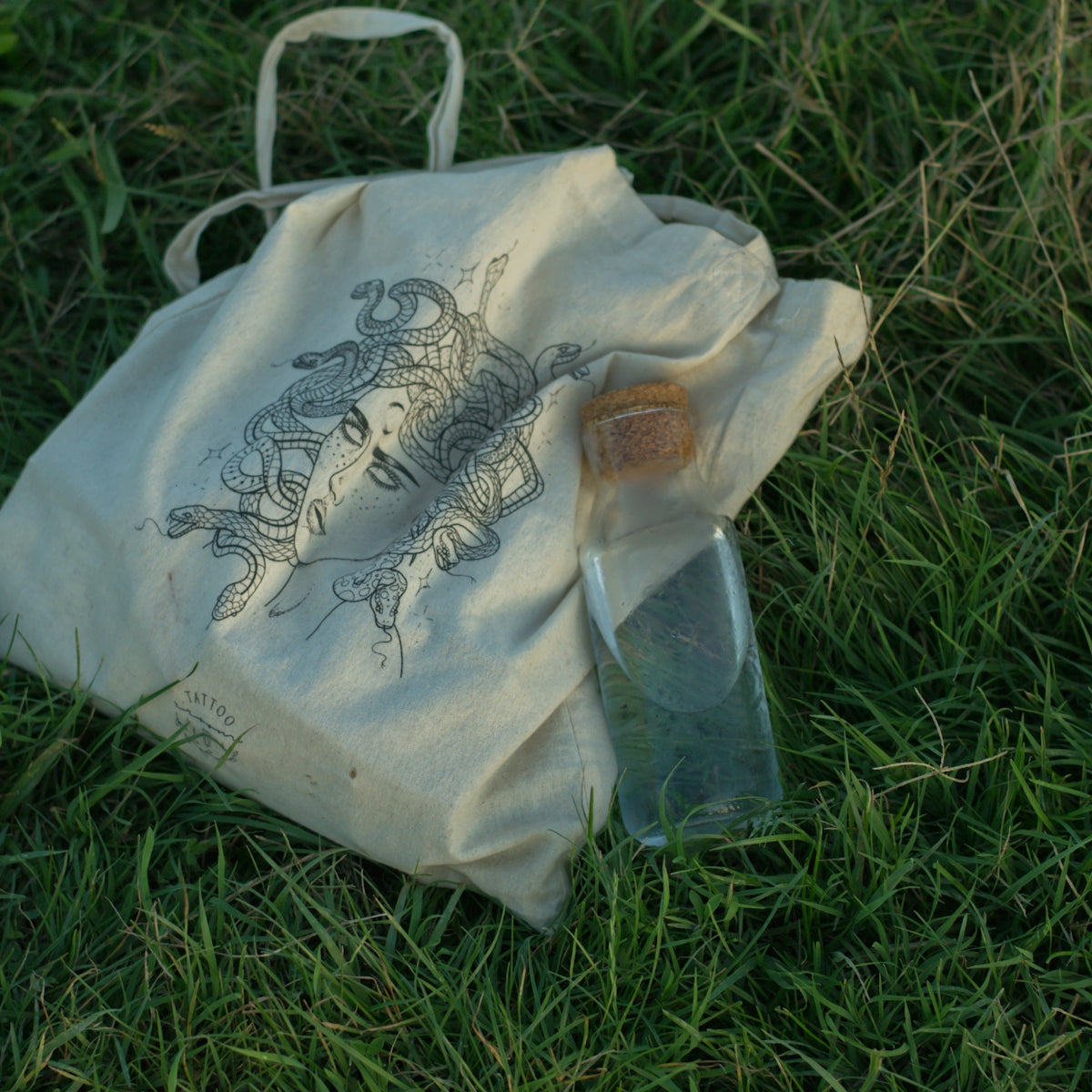 white and black tote bag on green grass