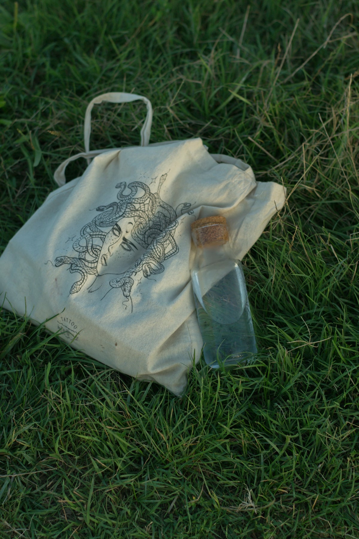 white and black tote bag on green grass