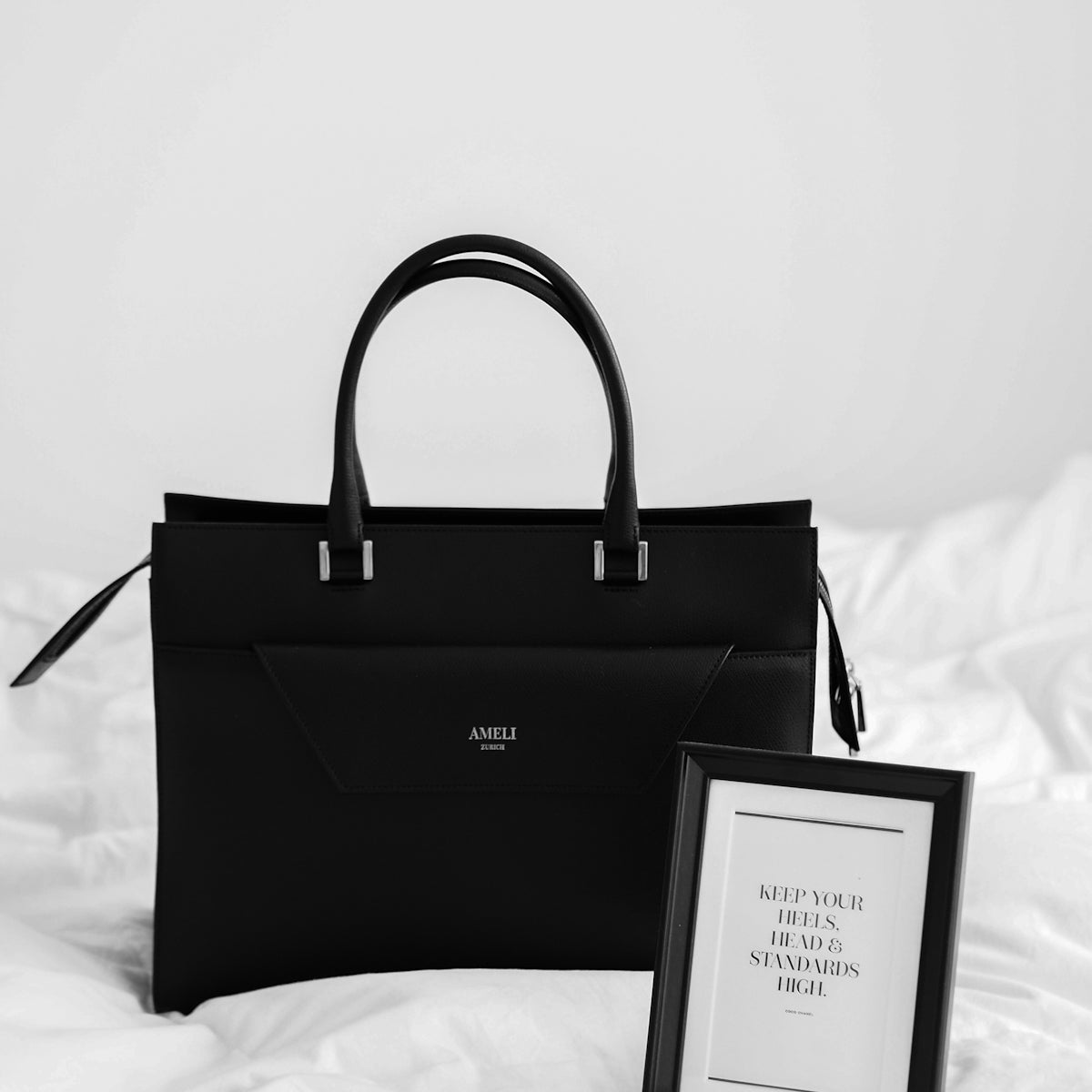 black and white paper bag on white textile