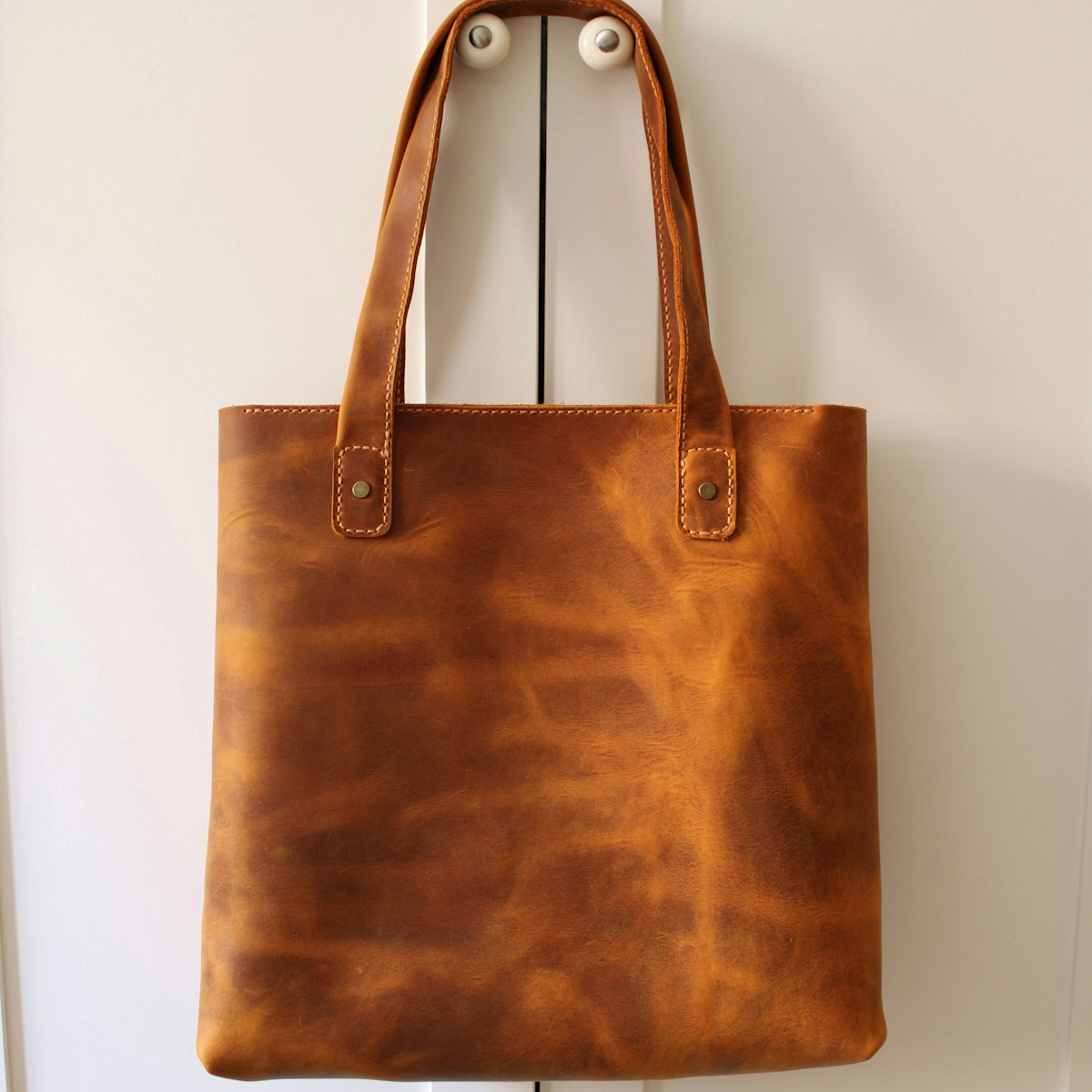 brown leather handbag on white table
