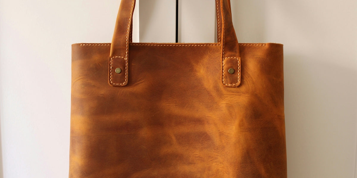 brown leather handbag on white table