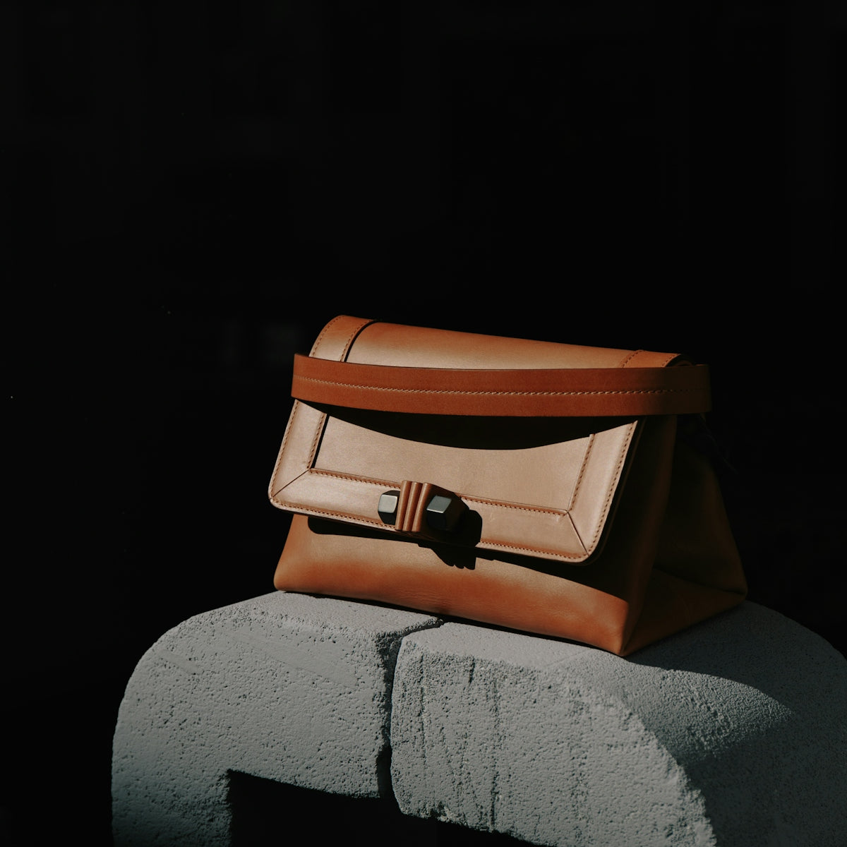 brown and black leather bag on gray textile