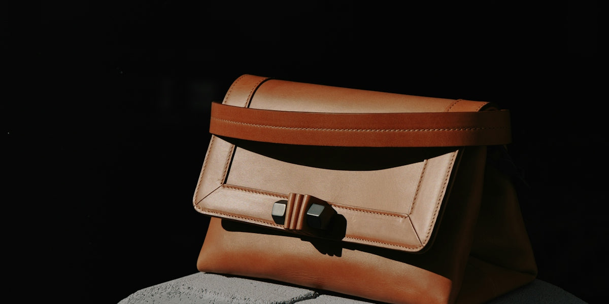 brown and black leather bag on gray textile