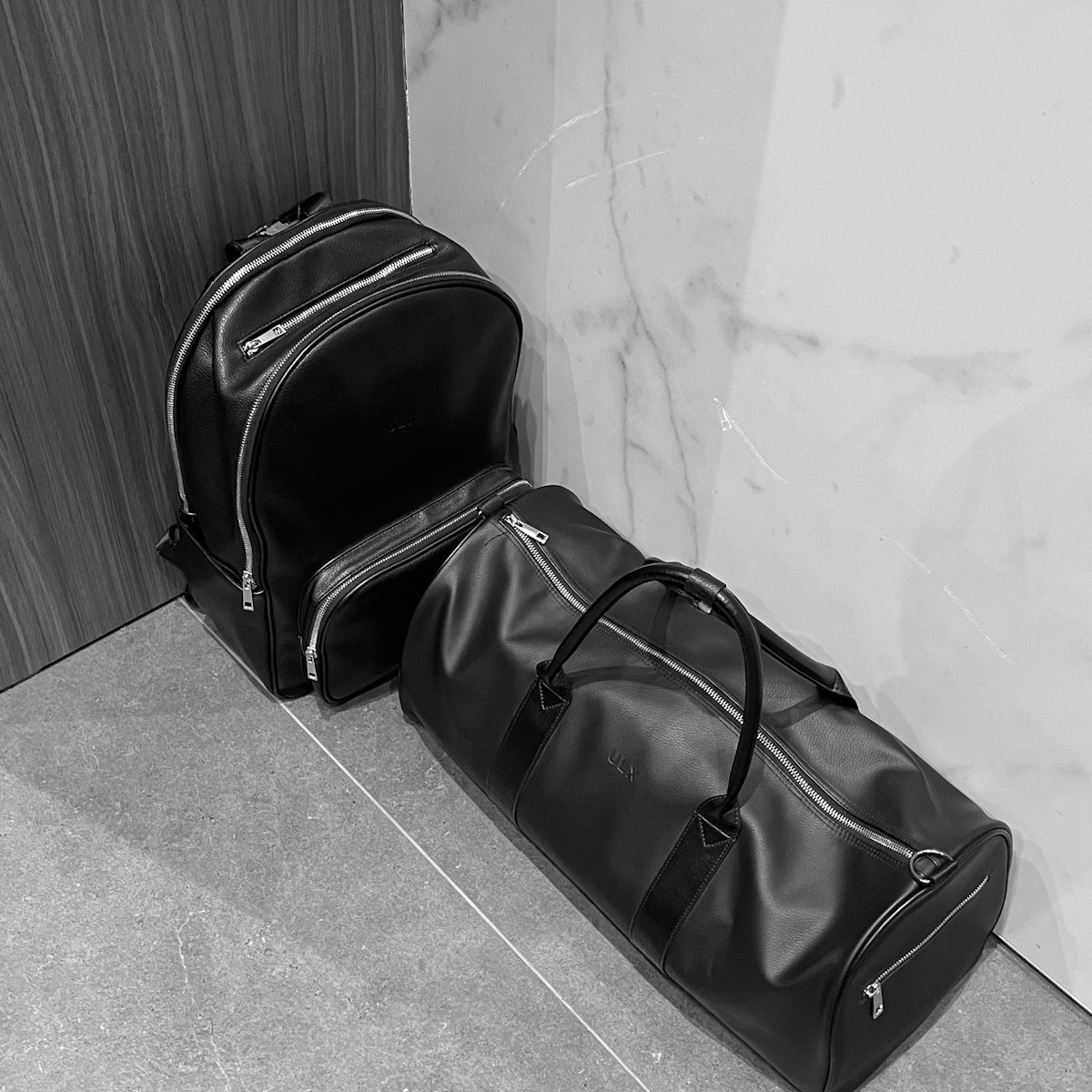 a black bag sitting next to a white wall