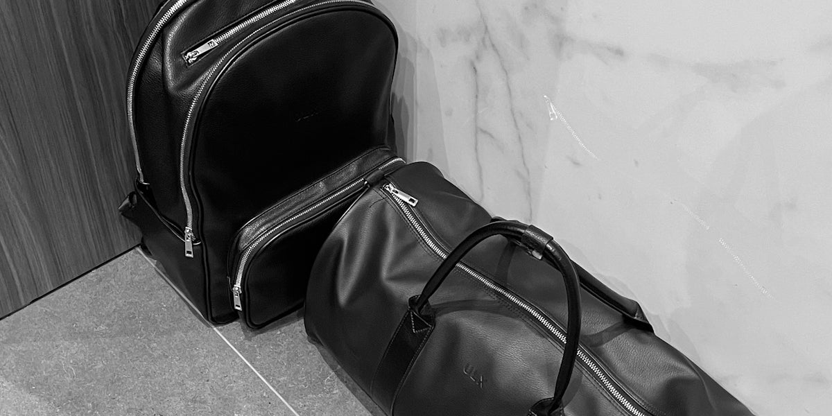 a black bag sitting next to a white wall