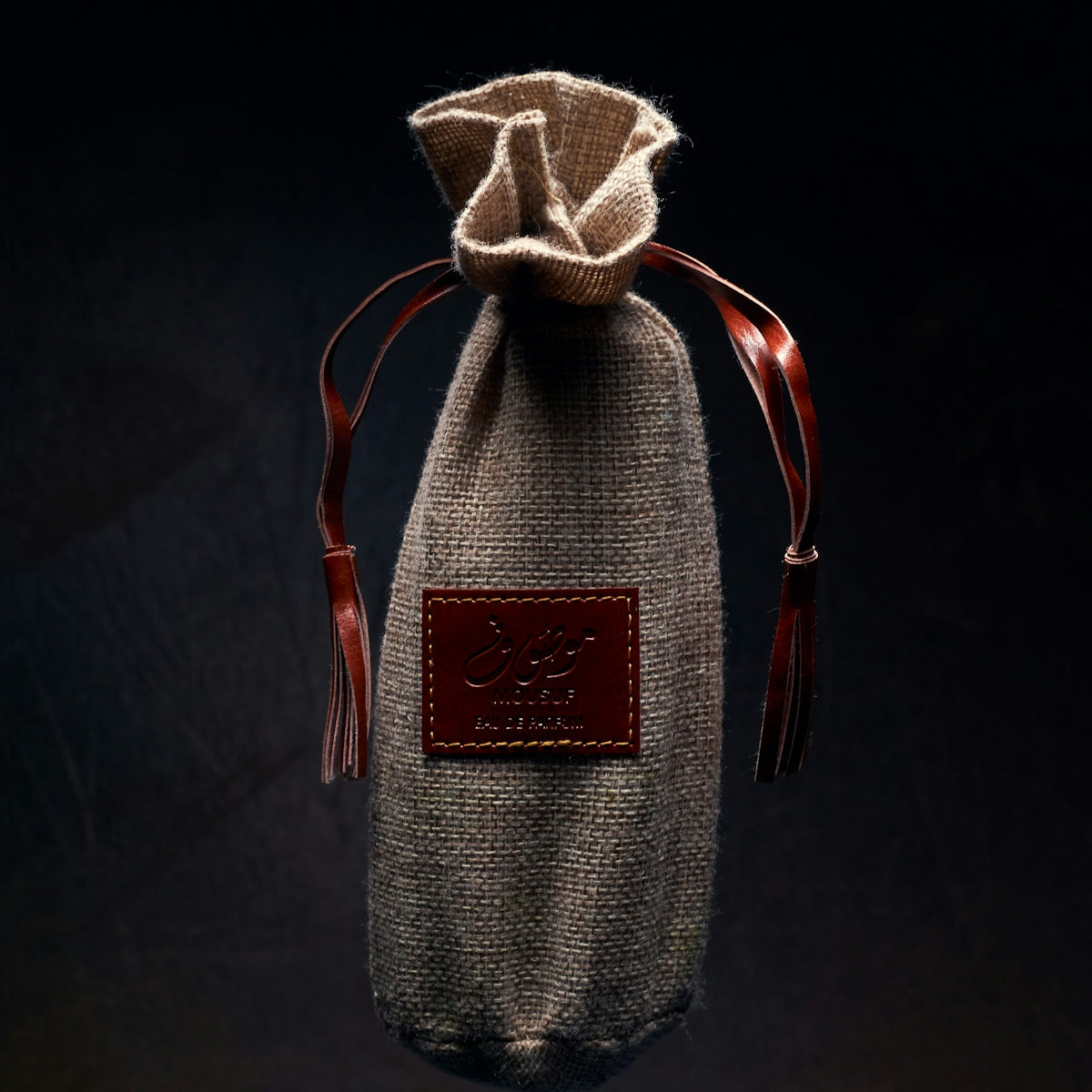 a small bag with a leather handle hanging from a string