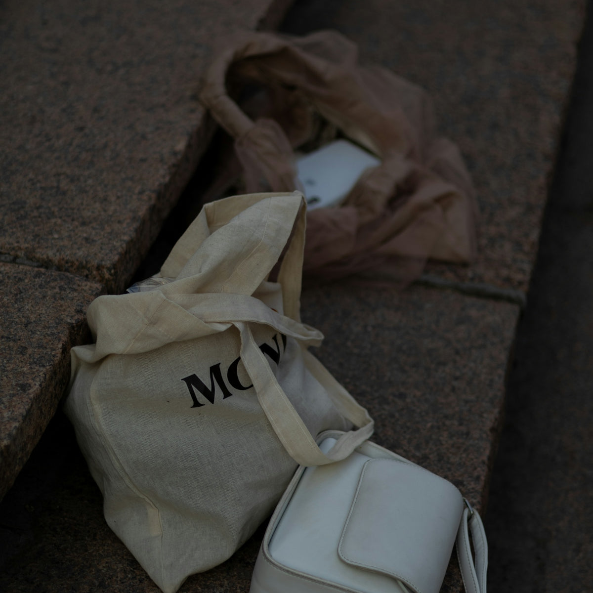 a white bag sitting on the ground next to a bag