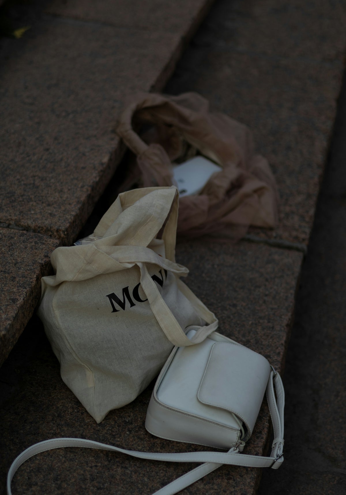 a white bag sitting on the ground next to a bag