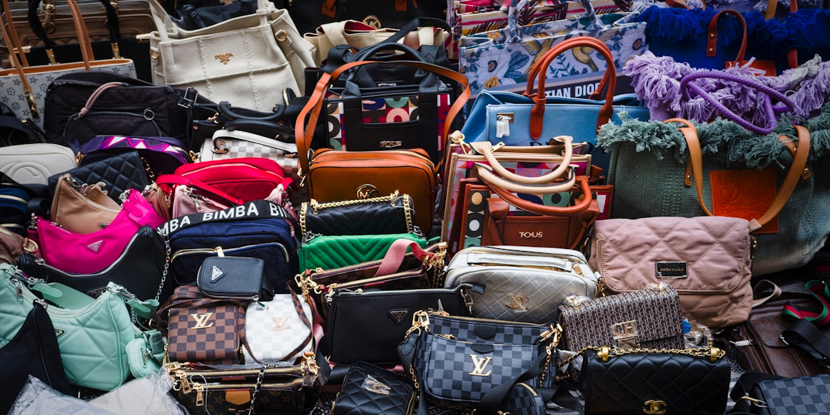 a pile of purses and handbags sitting next to each other