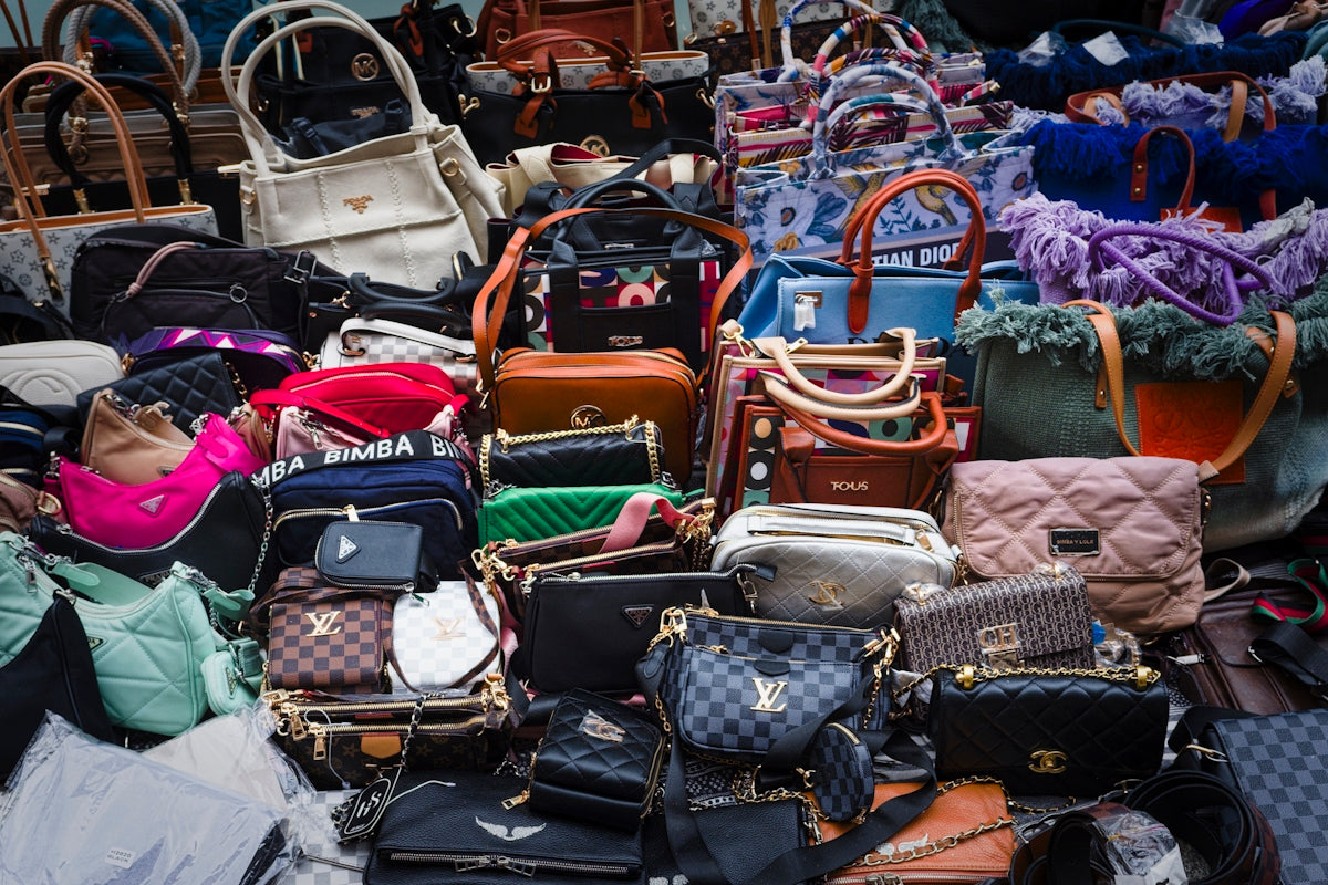 a pile of purses and handbags sitting next to each other