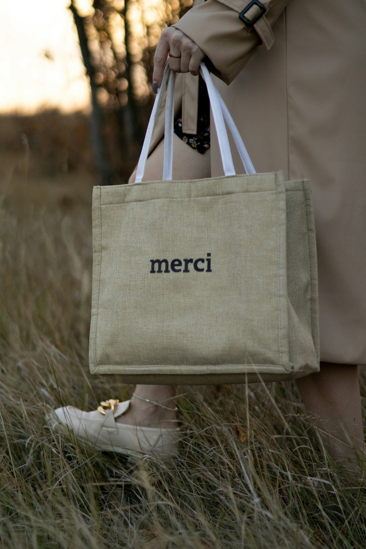 a person holding a bag with the word merci on it