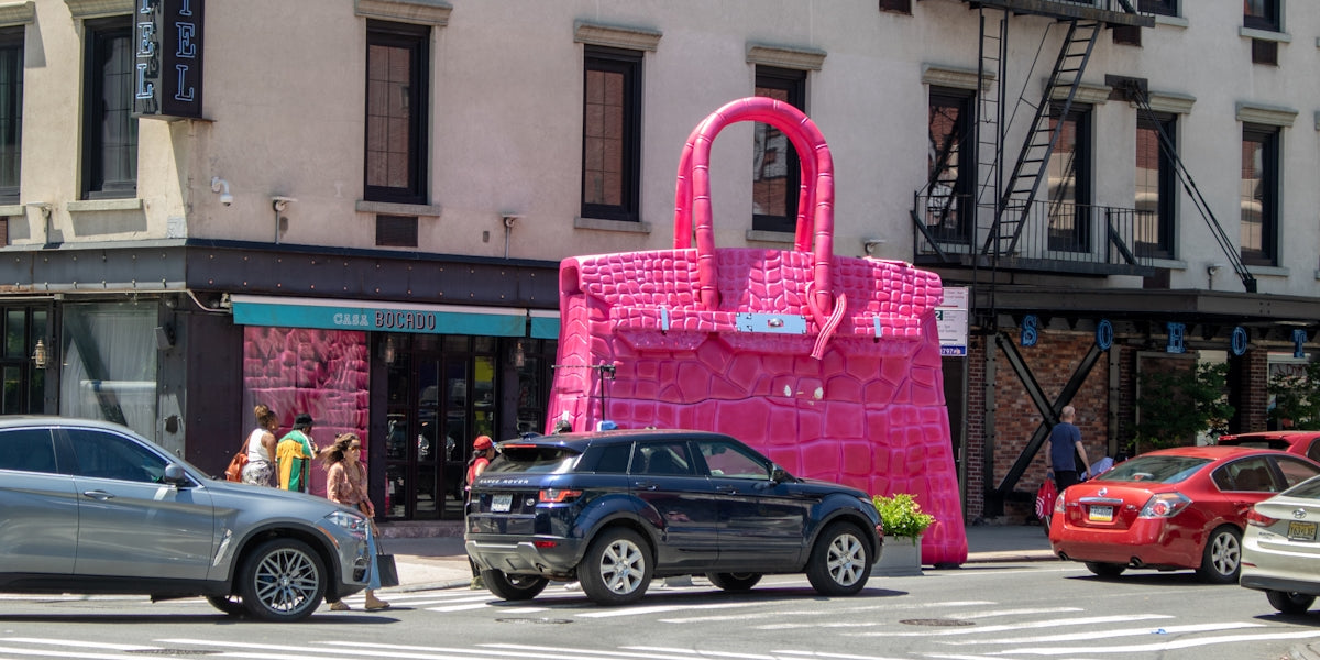 A large pink bag sitting on the side of a road