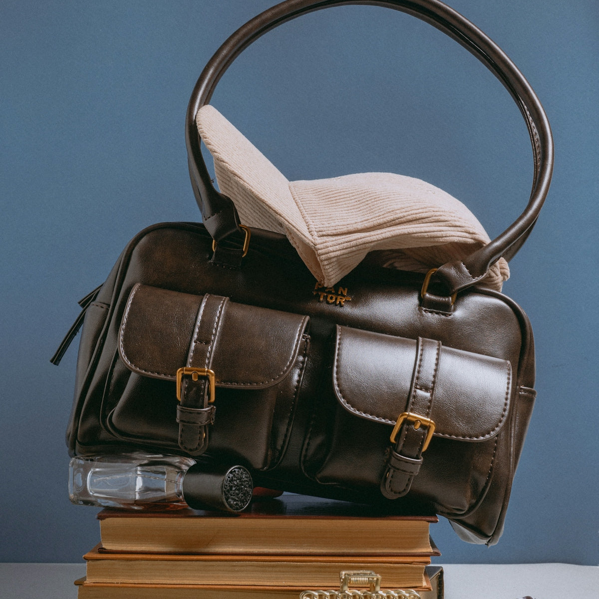 A brown bag sitting on top of a pile of books