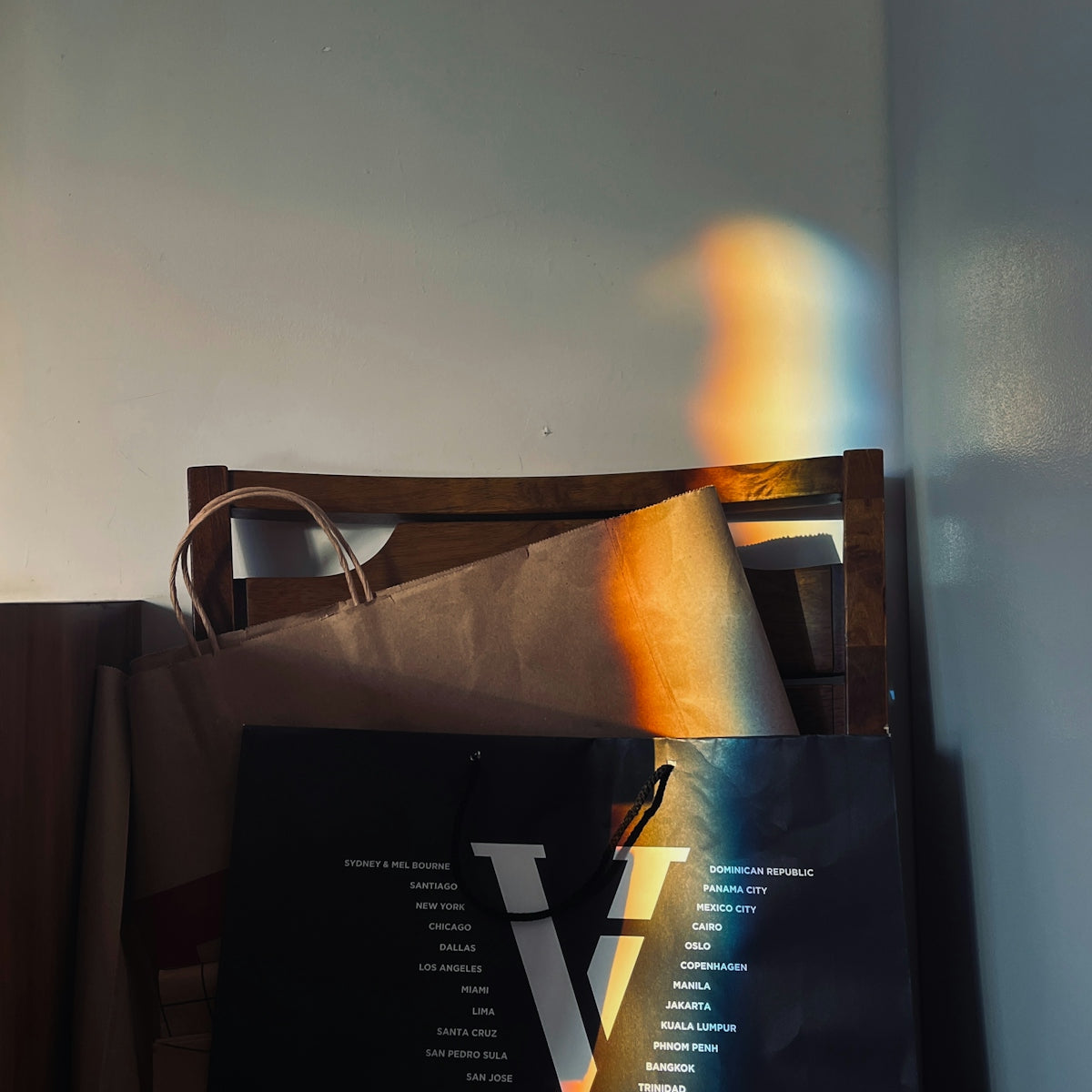 A black bag sitting on top of a wooden chair