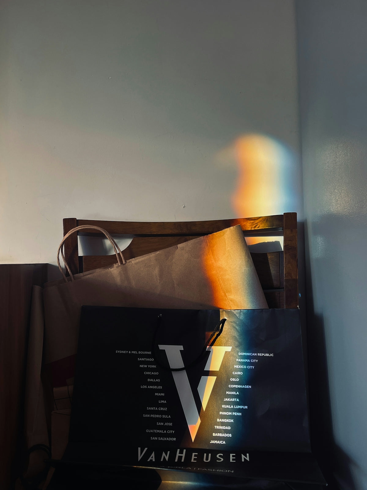 A black bag sitting on top of a wooden chair