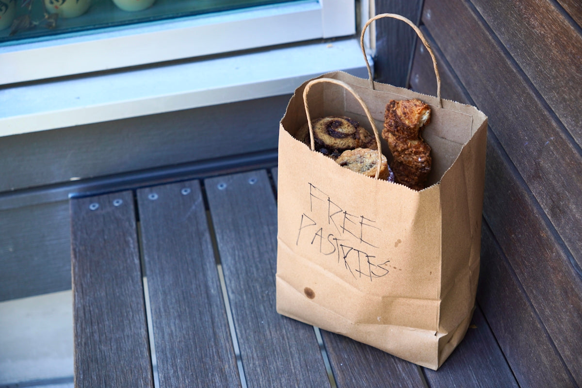 Free pastries in a brown paper bag.
