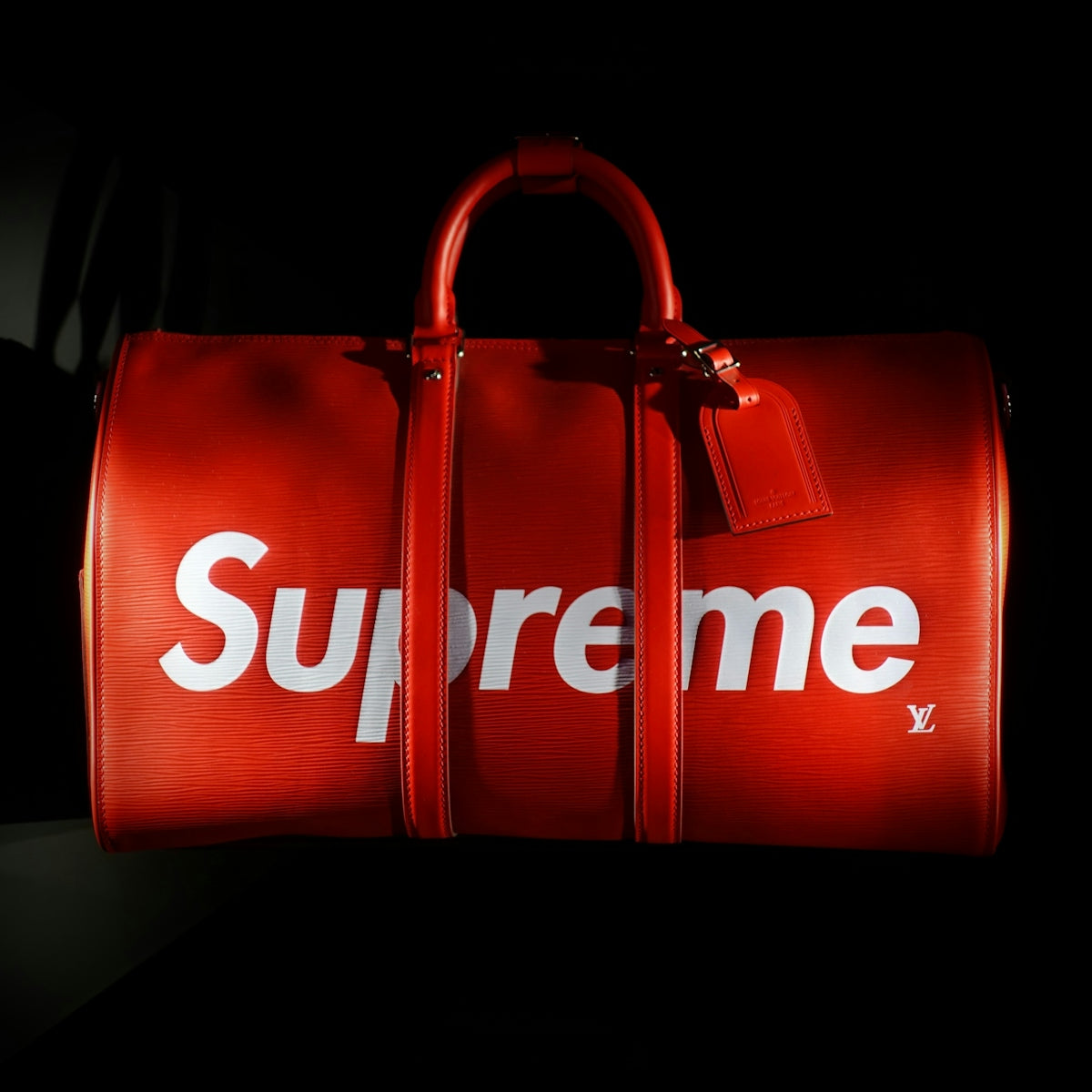 Red duffel bag with supreme logo
