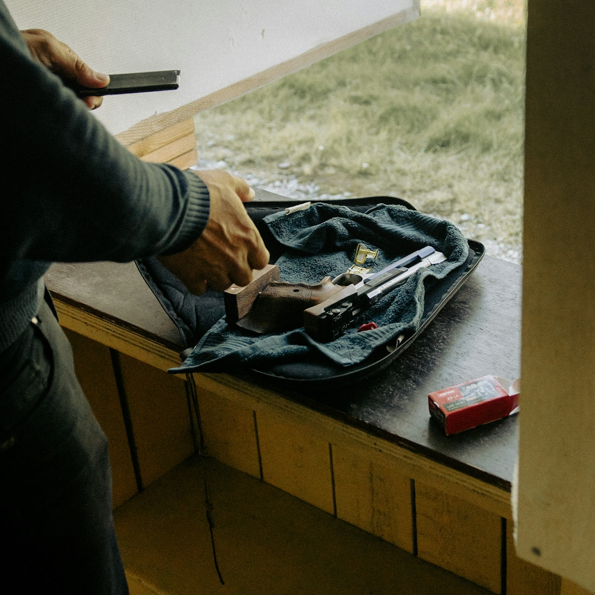 Person loading a handgun at a shooting range.