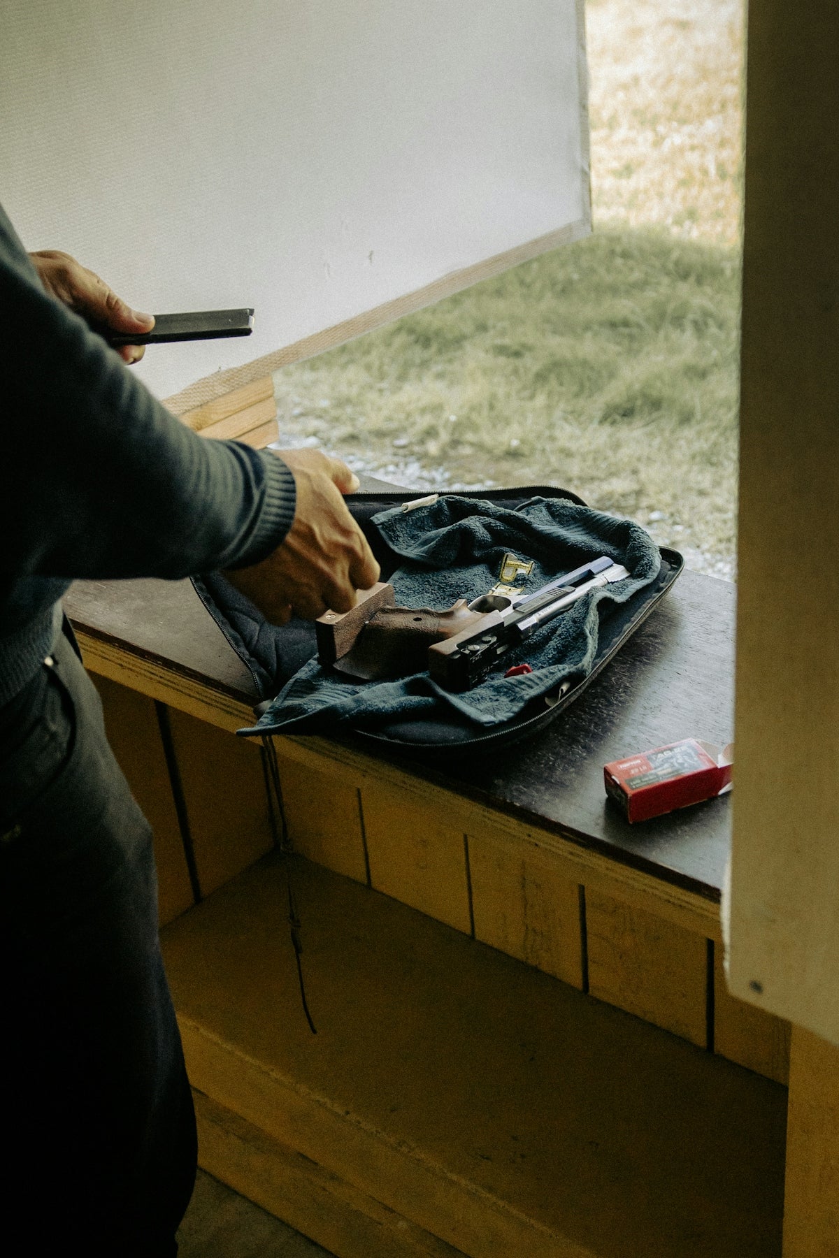 Person loading a handgun at a shooting range.