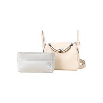 Beige luxury handbag with a matching gray inner bag organizer, both on white background