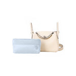 Light blue inner bag organizer in front of a cream luxury handbag on white background