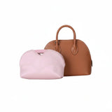 Pink inner bag organizer in front of a brown luxury handbag on white background.