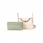 Green inner bag organizer in front of a beige luxury handbag on white background