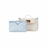 Light blue inner bag organizer next to a cream luxury handbag on white background