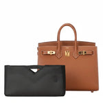 Black inner bag organizer in front of a brown luxury handbag with gold hardware