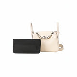 Black inner bag organizer in front of a light beige luxury handbag on white background