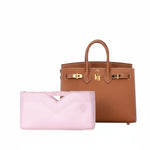 Pink inner bag organizer in front of a luxury brown leather handbag