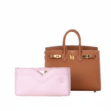 Pink inner bag organizer in front of a luxury brown leather handbag